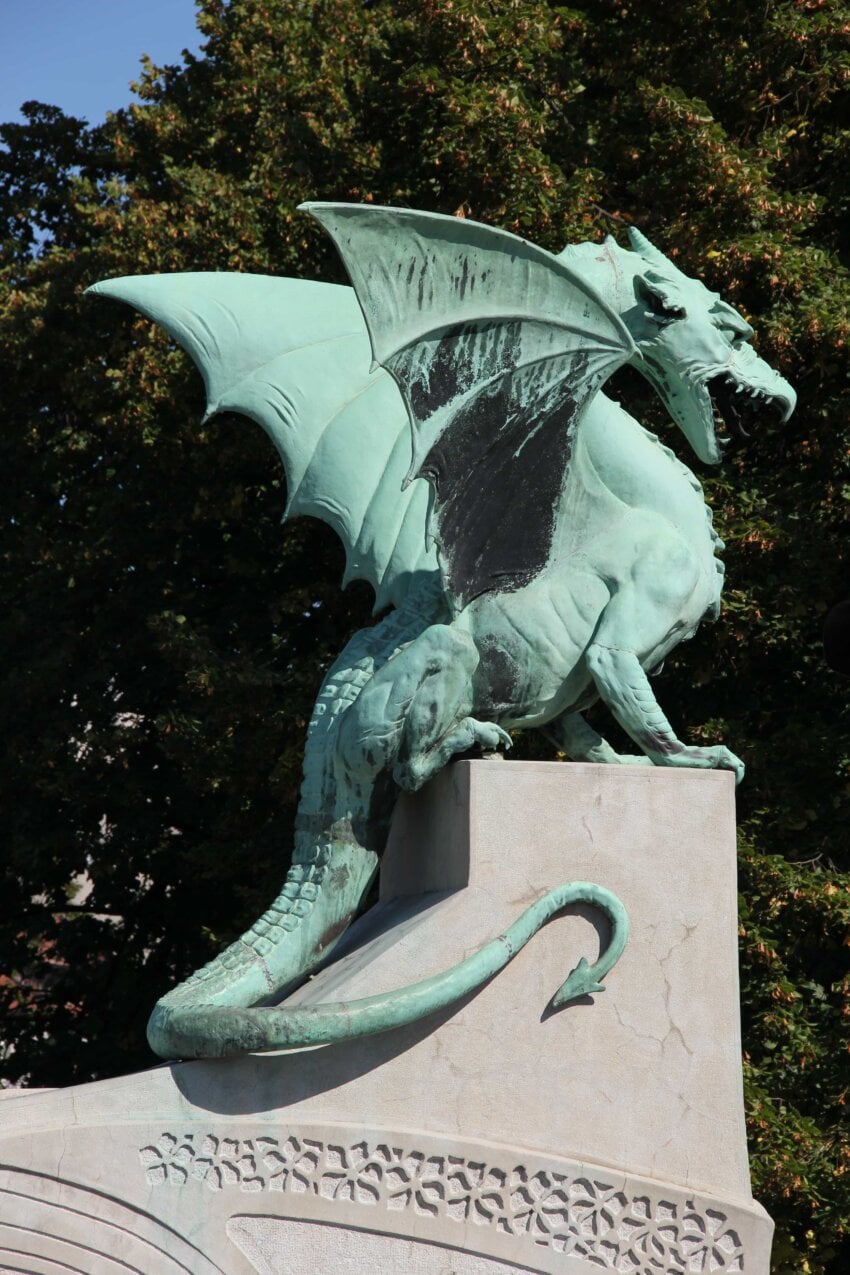A statue of a bronze western dragon atop decorative stone